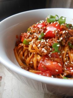 a white bowl filled with spaghetti and vegetables