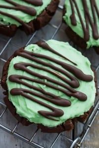 chocolate cookies with green frosting on a cooling rack