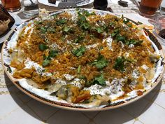 a large plate filled with food sitting on top of a table next to glasses and utensils