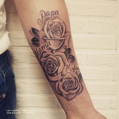 a woman with a tattoo on her arm that says papa mama and three roses in the center