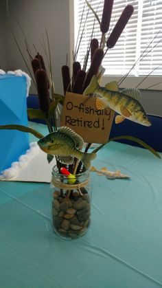 a jar filled with fish and rocks on top of a blue tablecloth covered table