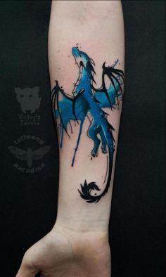 a blue and black dragon tattoo on the left arm, it looks like he is holding something in his hand