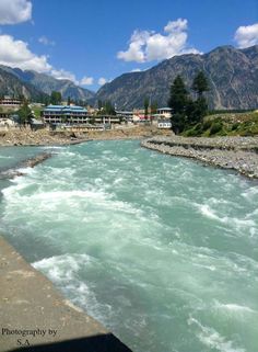 a river running through a town surrounded by mountains