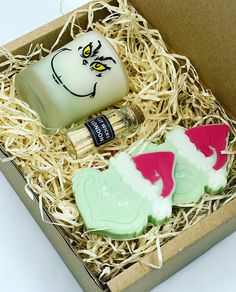 an open box with two decorated cookies in it and a bottle of cologne next to it