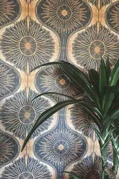 a potted plant sitting on top of a wooden table next to a wall paper