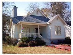 a white house with a blue roof and porch