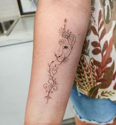 a woman's arm with a tattoo on it that has a lion in the middle