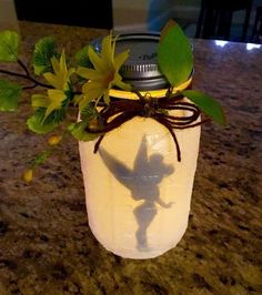 a mason jar with leaves and a shadow on the lid sitting on a counter top