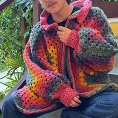 a woman sitting on steps wearing a crocheted jacket and jeans with her hands in her pockets