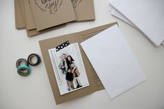 an open photo album sitting on top of a table next to some scissors and tape