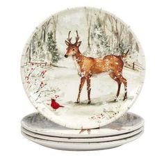 three plates decorated with deer in the snow and red cardinal bird on each plate,