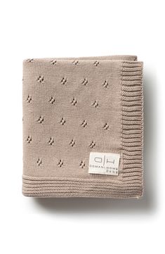 an image of a beige blanket on a white background with a tag that says h & m