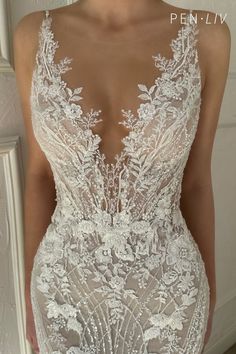 the back of a wedding dress with an intricate lace pattern and sheer, low neckline