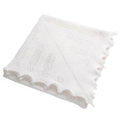 a white knitted blanket with scalloped edges