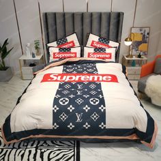 a bed with black and white comforter, red supreme logo on the pillow cover