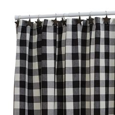 the black and white checkered curtains are hanging on a metal rod, with stars at the top