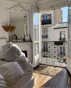 an open door leading to a bedroom with a balcony and bed in the foreground