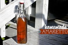 a glass bottle filled with liquid sitting on top of a wooden porch next to a fence