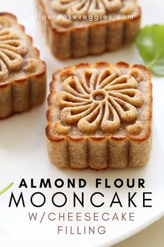 almond flour mooncakes with cheesecake filling on a white plate and green leaves in the background