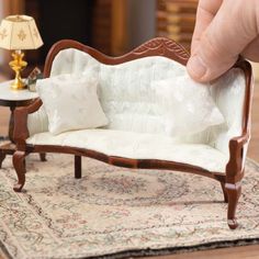 a miniature couch sitting on top of a rug next to a table with a lamp