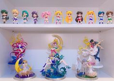 some anime figurines are on display in a white shelving with shelves full of them