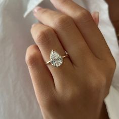 a woman's hand with a diamond ring on it