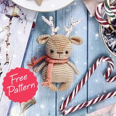 a crocheted stuffed animal sitting on top of a table next to candy canes