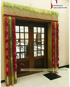 an entrance decorated with red and green flowers