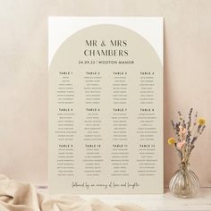 a wedding seating chart with flowers in a vase