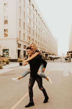 a man carrying a woman across the street