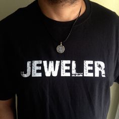 a man wearing a black t - shirt with the word jeweler on it