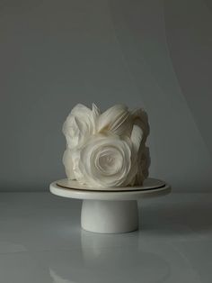 a white cake sitting on top of a plate covered in frosting flowers and icing