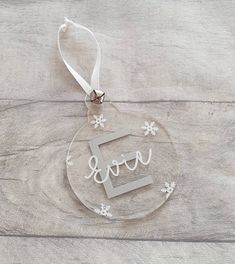 a glass ornament with the word love hanging from it's side on a table