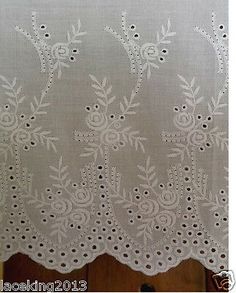 an embroidered curtain with white flowers on it