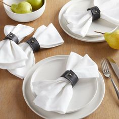 the napkins are wrapped in black ribbon and placed on white plates with silverware