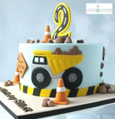 a birthday cake with a dump truck on top and the number 2 in the middle