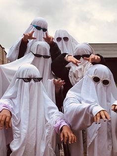 several people dressed in white are posing for the camera