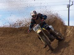 a man riding a dirt bike on top of a dirt field