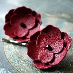 two red flowers are sitting on a table