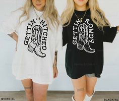 two women standing next to each other wearing black and white shirts with cowboy boots on them