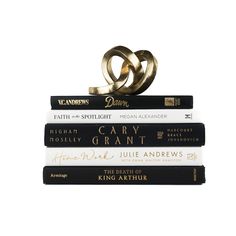 three books stacked on top of each other with two gold rings sitting atop one another