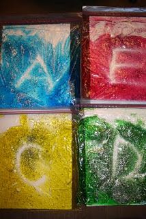 four different colored powdered letters are in plastic bags with the letter d on them