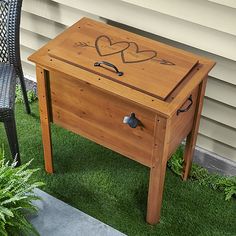 a wooden table sitting on top of grass next to a chair