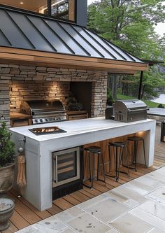 an outdoor kitchen with grill and bar stools