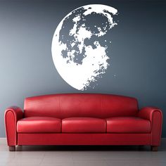 a red leather couch sitting in front of a wall with the moon drawn on it