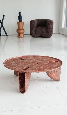 a coffee table sitting on top of a white floor next to a chair and window