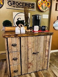 a wooden cabinet with many drawers and coffee cups sitting on it's sideboard