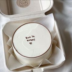 a white bowl with writing on it sitting in a cardboard box next to an empty container