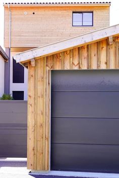 two garages side by side in front of a house with wooden siding and windows