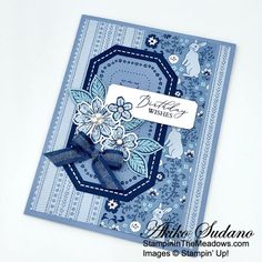 a close up of a greeting card on a white surface with blue flowers and butterflies